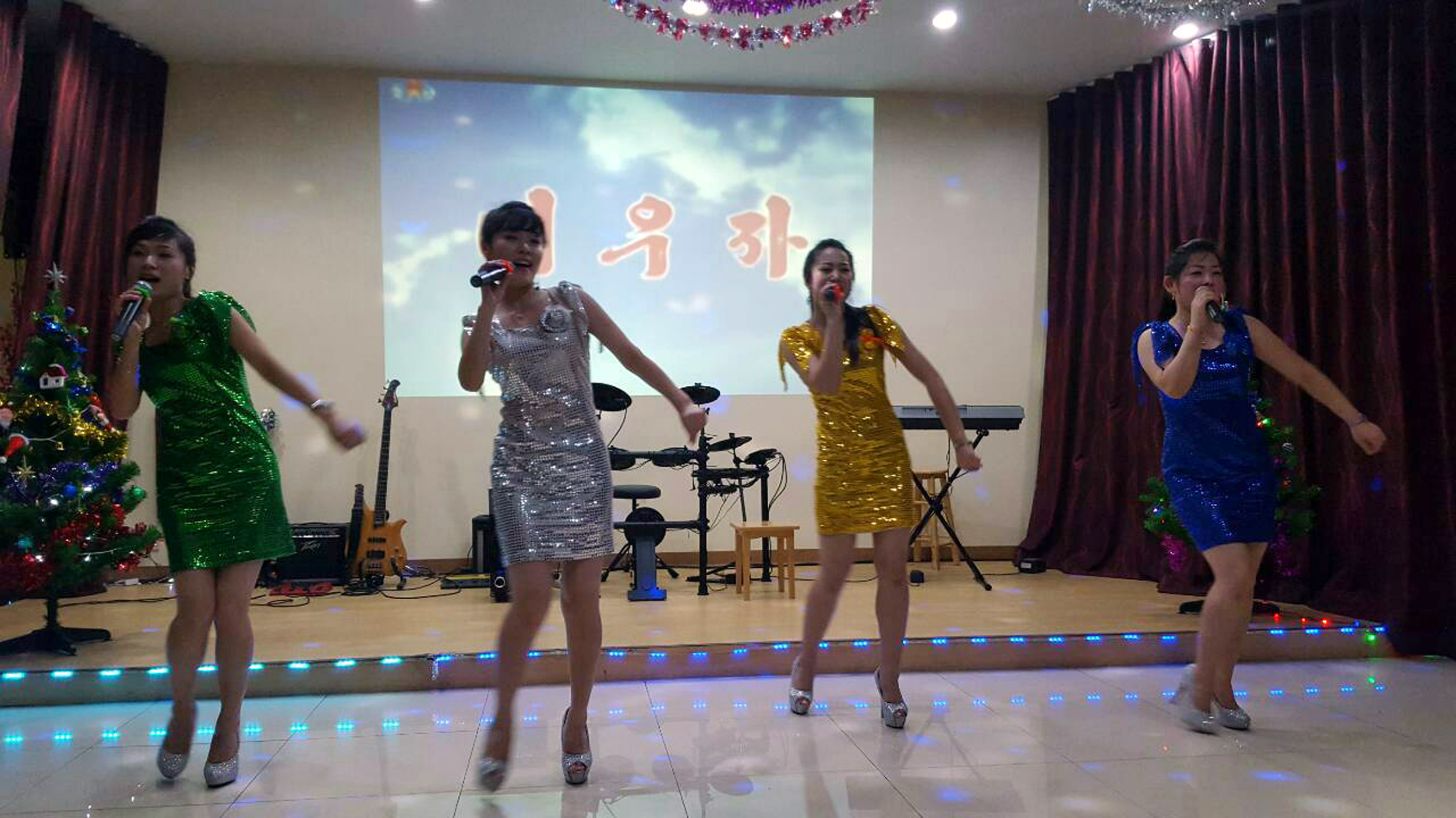 In this Feb. 18, 2016, photo, North Koreans, who are also the waitresses and the singers, perform K-pop dancing and sing at the Pyongyang A Ri Rang Restaurant in Bangkok, Thailand. The Bangkok show was a half-hour of skilled performances and lightning-fast costume changes, from traditional hanboks to sparkly short dresses in the style of K-pop girl bands. A slideshow in the background depicted flowers, landscapes, tundra and a river full of dead fish. (AP Photo)