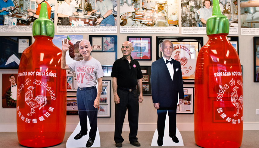 David Tran CEO of Huy Fong Foods with cutouts of himself and Sriracha bottles full
